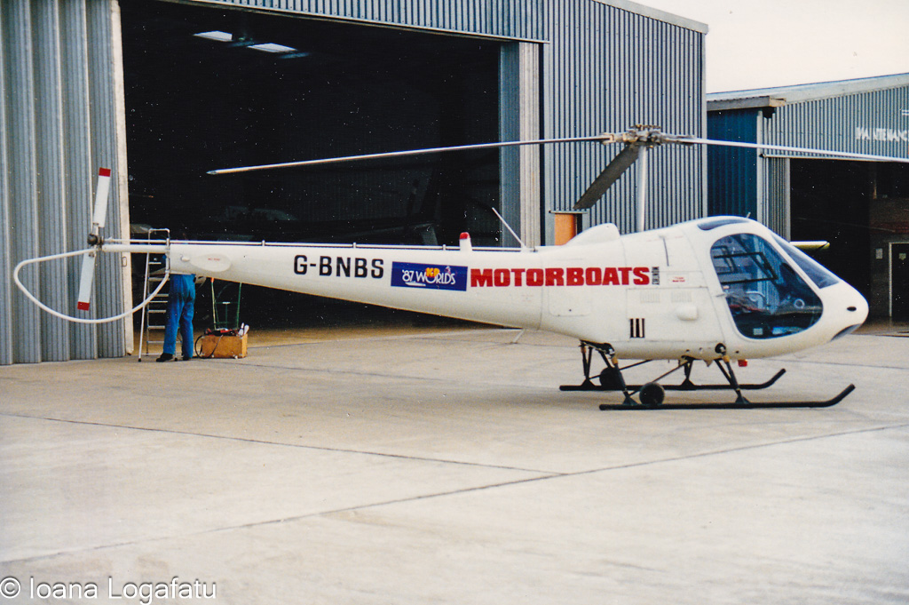 Helicopter parked outside hangar during bright day