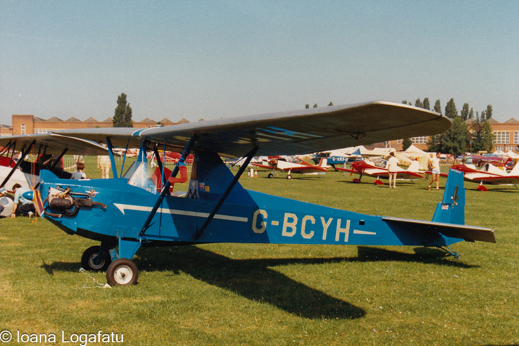 Vintage blue aircraft on a sunny airfield day
