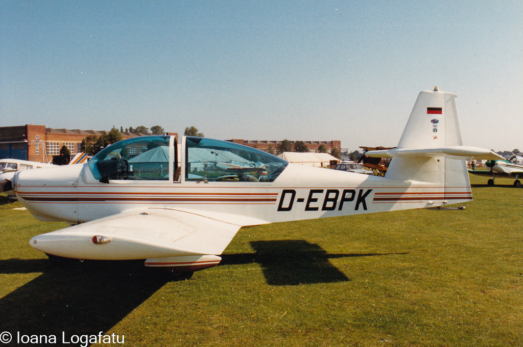 Classic aircraft parked on a sunny airfield
