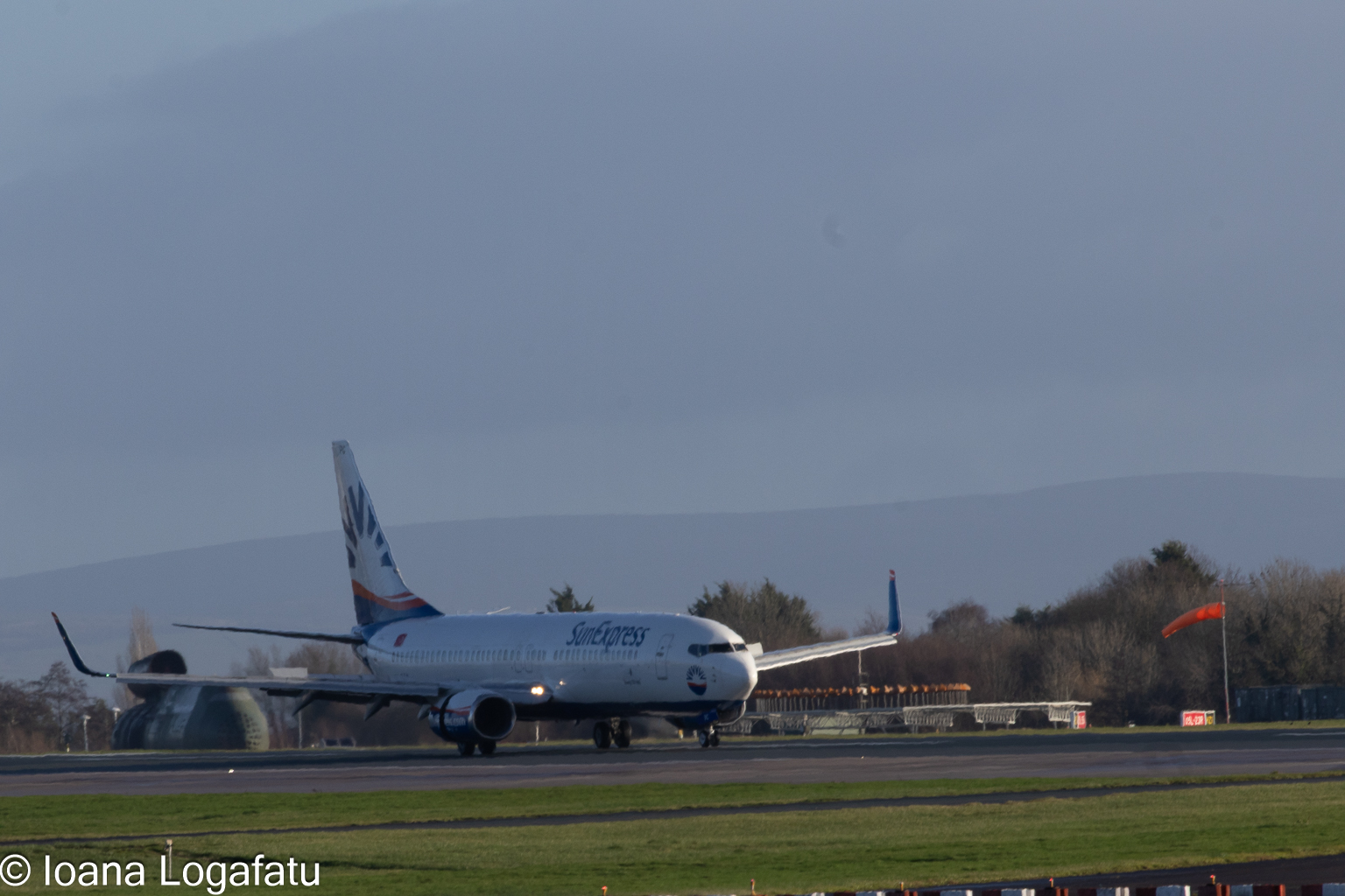 Plane takes off at sunny airport near mountains