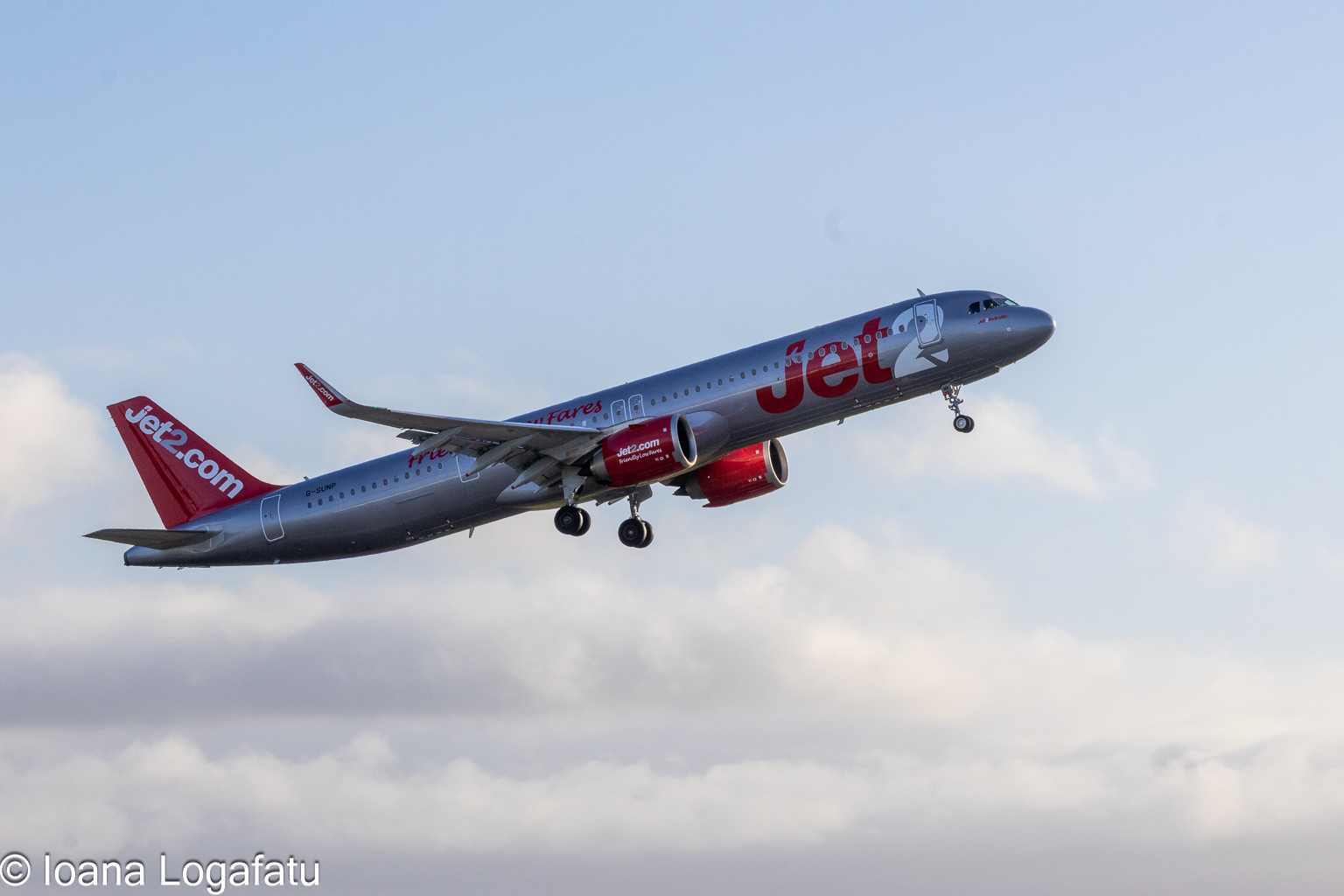 Airplane soaring high against a bright blue sky