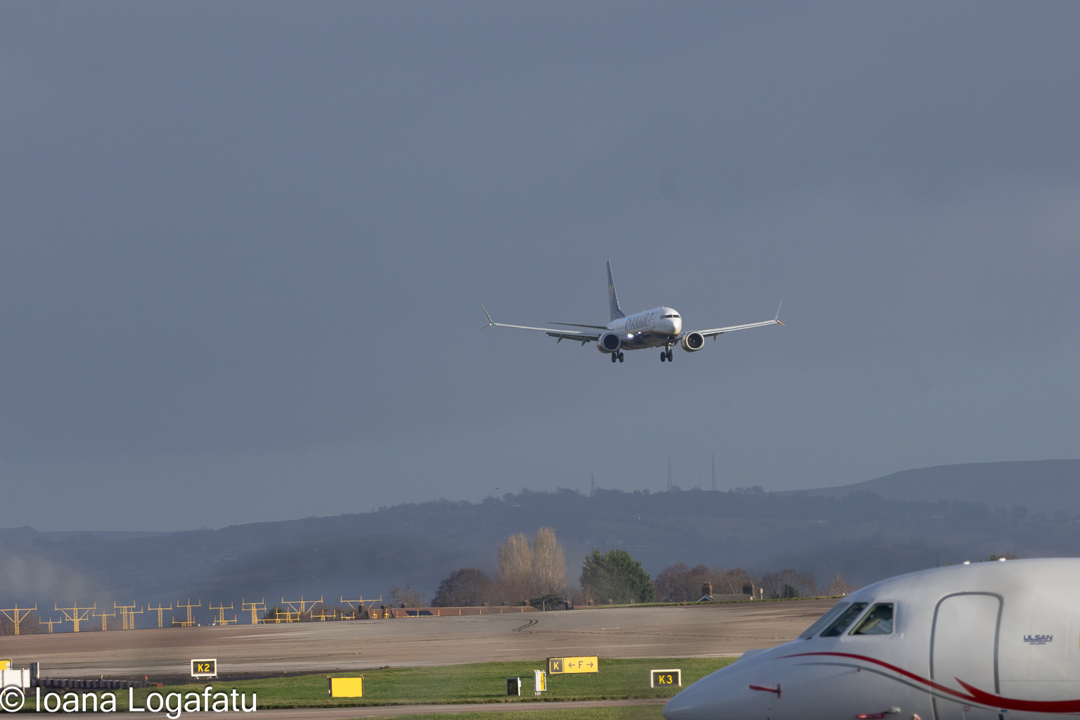 Airplane approaches runway under dramatic sky