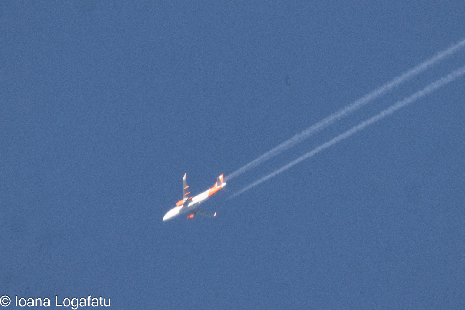 Plane soaring high under the clear blue sky