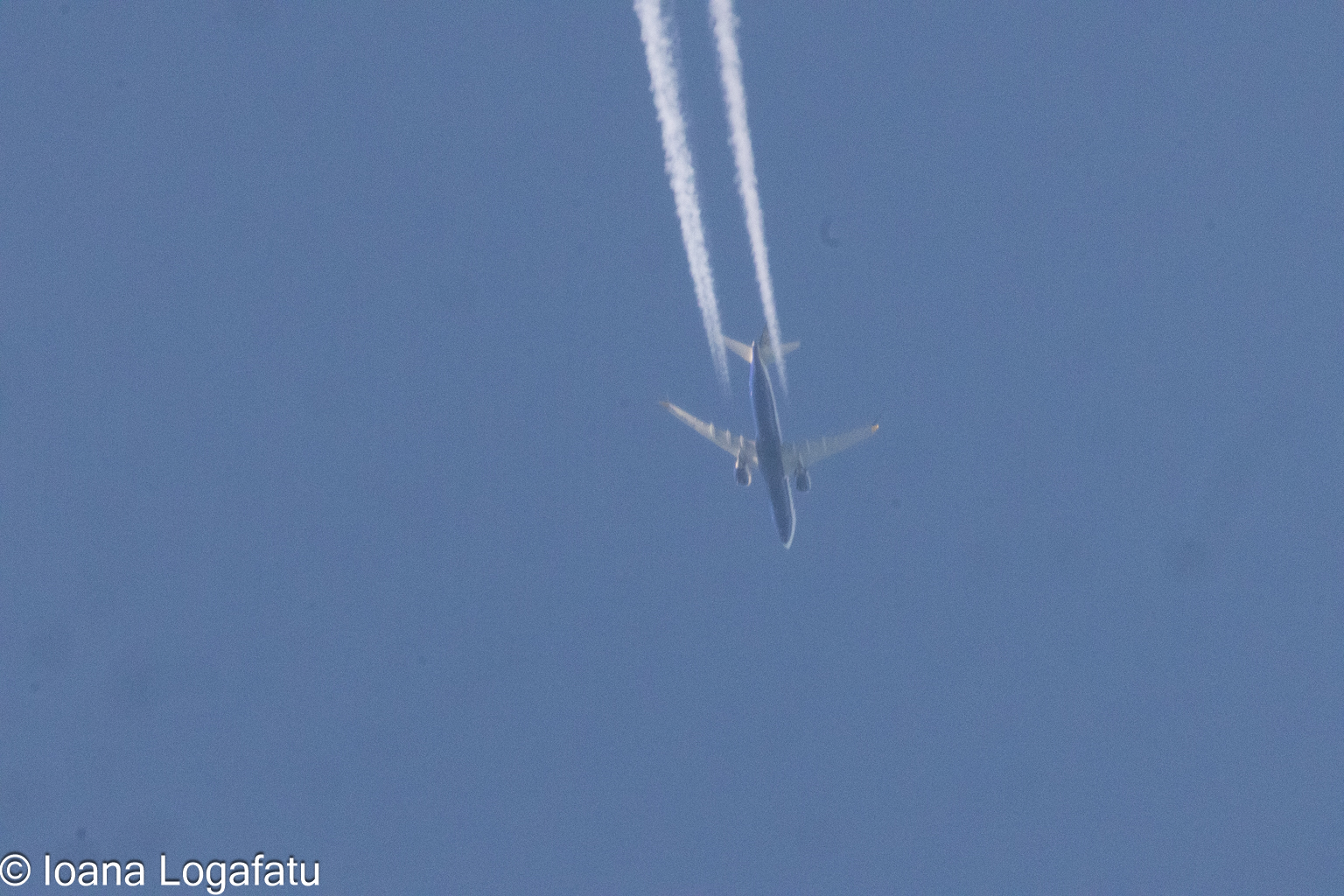 Airplane soaring through a clear blue sky