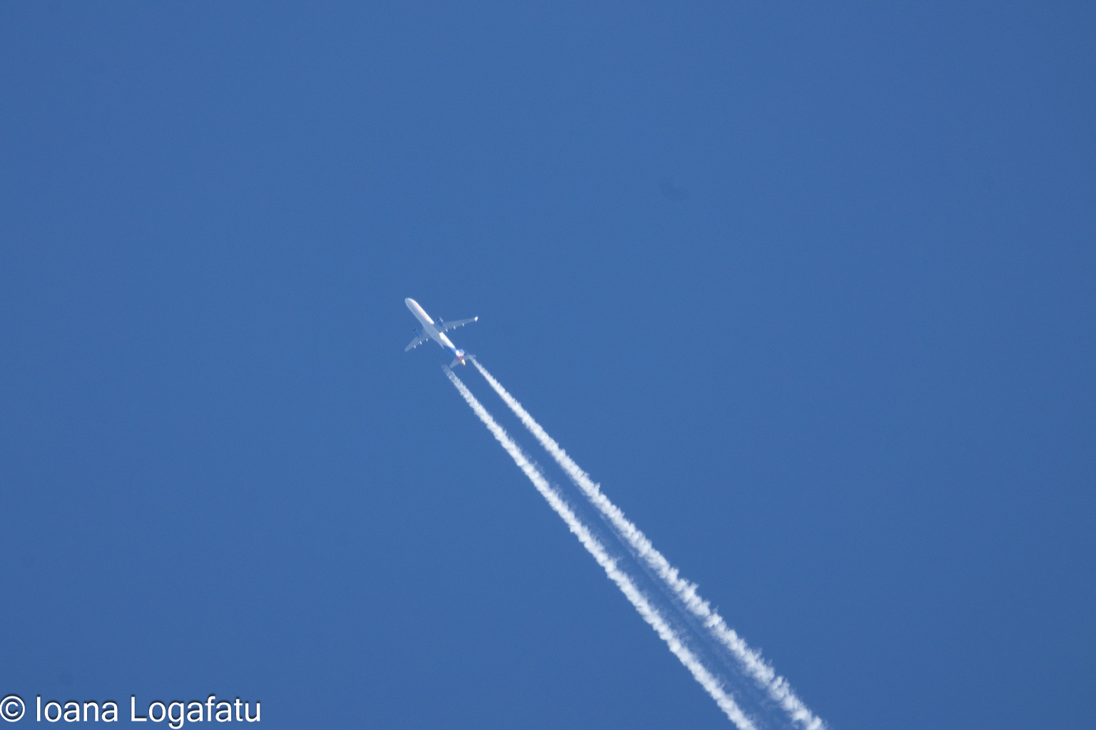 Airplane soaring high in the clear blue sky