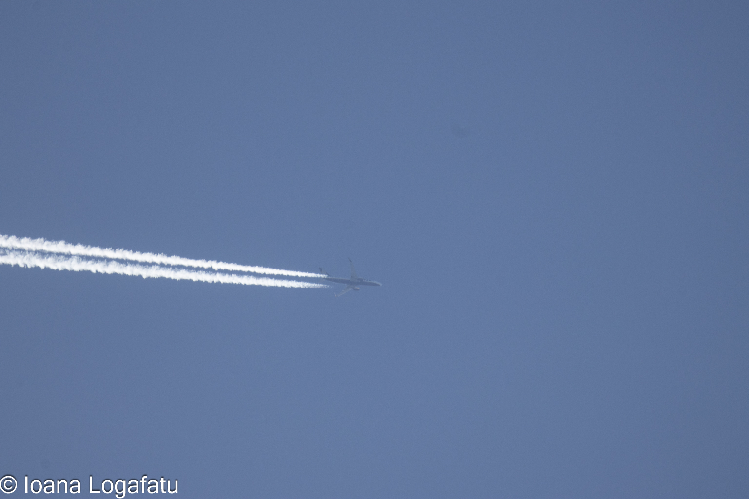 Above the clouds, a plane trails dreams