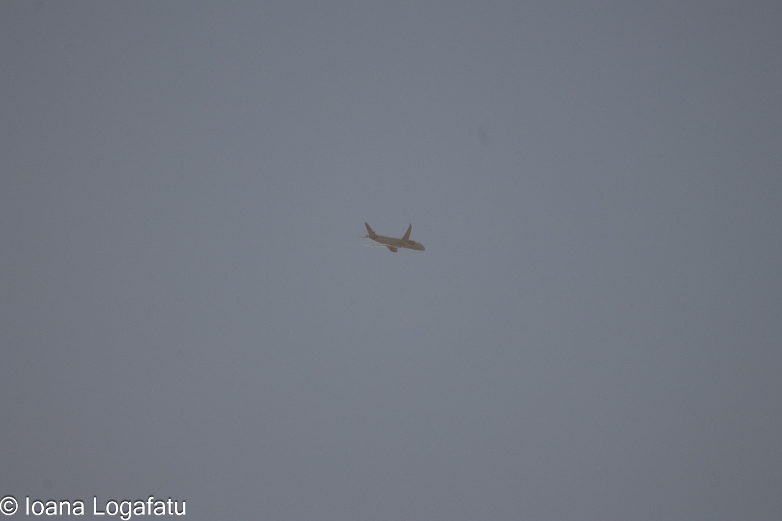 Aircraft flying through a misty sky at dusk