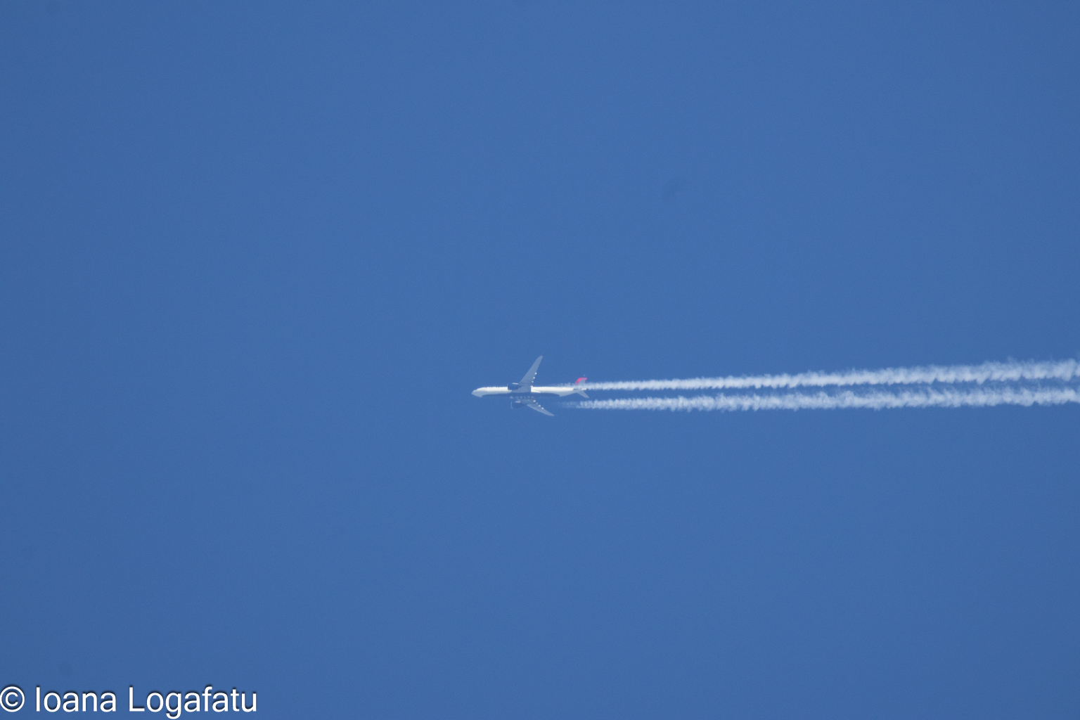 Jet soaring through a bright blue sky above
