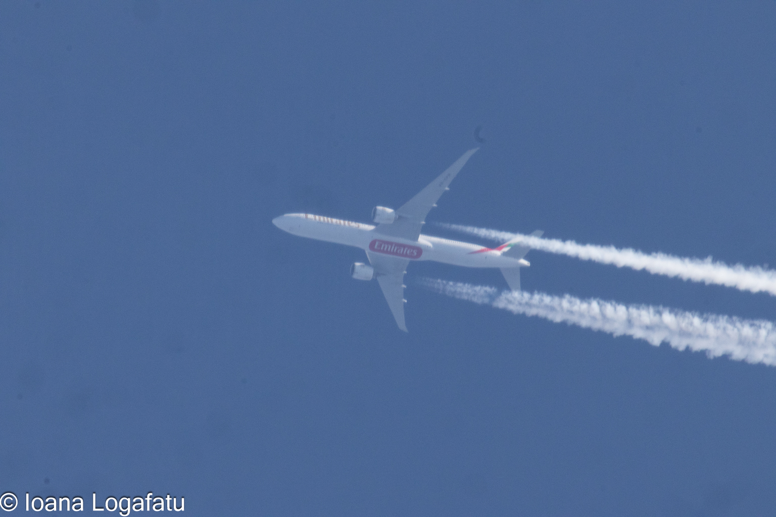 Jet carving trails through a bright blue sky