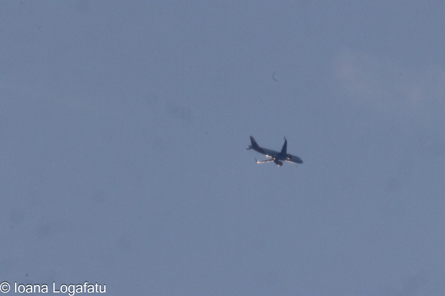 Airplane soaring through a cloudy sky in daylight