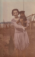Woman holding dog in a garden from the past