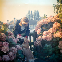 Corgi plays with girl near blooming flowers