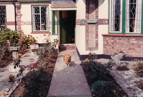 Dog running in front of a charming home garden