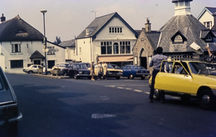 Busy street scene with classic cars from the past
