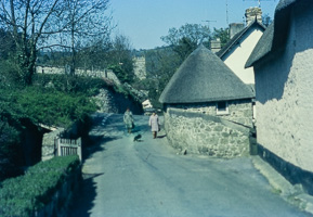 Charming village road with cottages and walkers