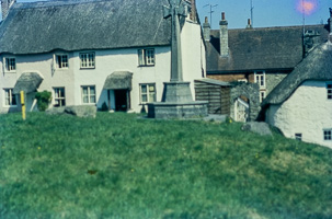 Old village houses beside a stone monument