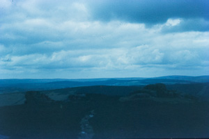 Scenic view of distant mountains under cloudy sky