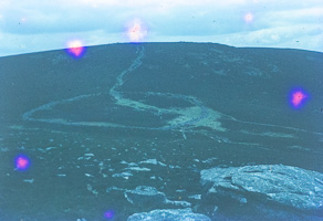 Hikers on winding trail in mountain landscape
