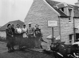 Group of travelers posing outside a cozy lodging