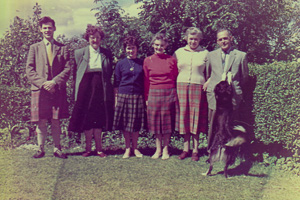 Family gathering in a garden with a dog