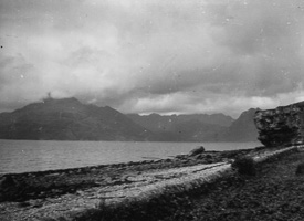 Coastal landscape with mountains under cloudy sky