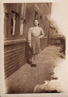 Woman in vintage dress standing by brick building