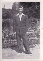 Man in stylish outfit standing near garden chair