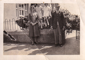 Family gathering in front of a vintage home