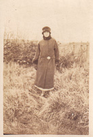 Elegant figure in winter attire amidst grass