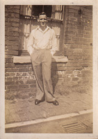 Young man poses confidently by brick wall