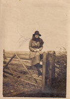 Woman sitting gracefully on a rustic gate