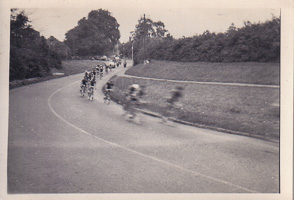Cyclists racing around a bend on a road in summer