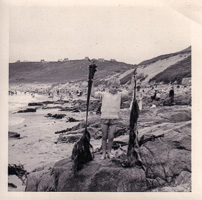 Child enjoys beach day holding seaweed treasures