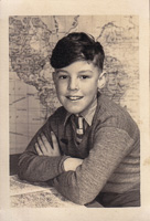 Young boy smiling in front of a world map backdrop