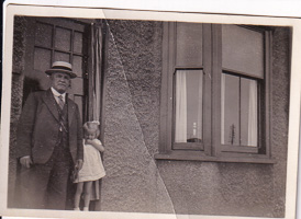 Elderly gentleman and child near a quaint building