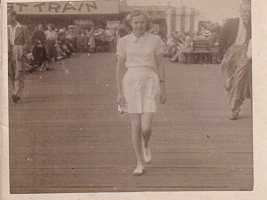 Woman walking confidently on a busy pier in summer