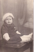 Charming child in vintage outfit seated