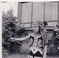 Young child in playful costume pointing outside