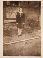 Woman stands proudly near brick wall on street