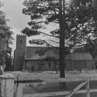 Historic stone church surrounded by lush trees