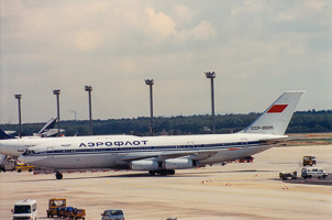Historic Soviet-era aircraft at bustling airport