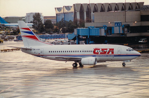 Vintage aircraft on rainy runway at busy airport