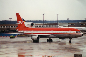Red aircraft preparing for takeoff on a rainy day