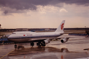 Airliner on tarmac under cloudy skies at dusk