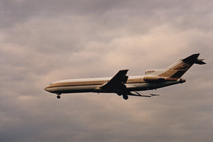 Old plane glides beneath cloudy sky