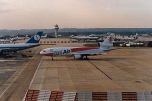 Airplane taxiing on a runway at a busy airport