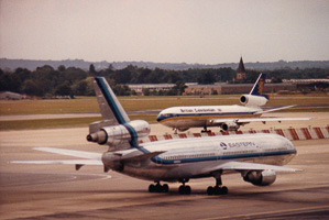 Vintage aircrafts at a bustling airport in the 80s