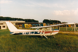 Small aircraft parked on grassy airfield at sunset