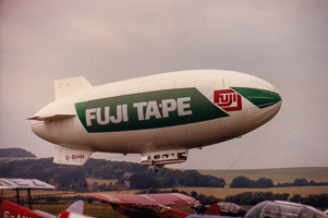 Blimp gracefully soaring over a vintage airfield