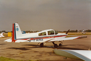 Vintage aircraft at a sunny airfield on a calm day